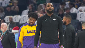 Dec 25, 2024; San Francisco, California, USA; Los Angeles Lakers guard Bronny James (center left) and forward LeBron James (center right) stand on the court before the game against the Golden State Warriors at Chase Center. Mandatory Credit: Darren Yamashita-Imagn Images