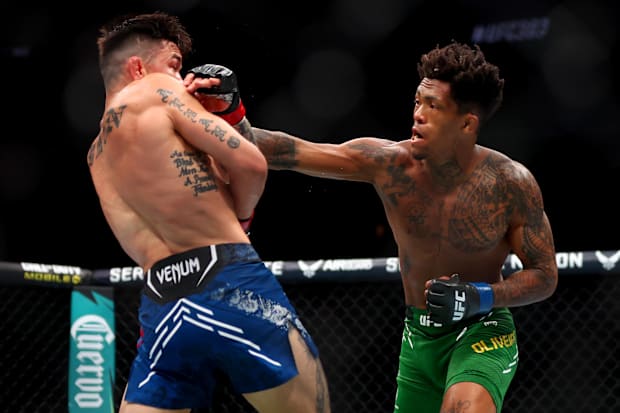 Ricky Simon (red gloves) fights Vinicius Oliveira (blue gloves) during UFC 303 at T-Mobile Arena. 