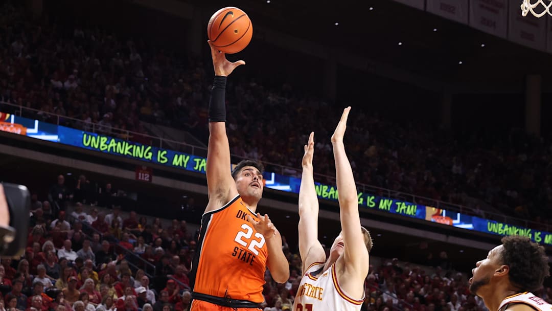 Jan 10, 2026; Ames, Iowa, USA; Oklahoma State Cowboys center Parsa Fallah (22) scores over Iowa State Cyclones forward Dominykas Pleta (21) during the second half at James H. Hilton Coliseum. Mandatory Credit: Reese Strickland-Imagn Images
