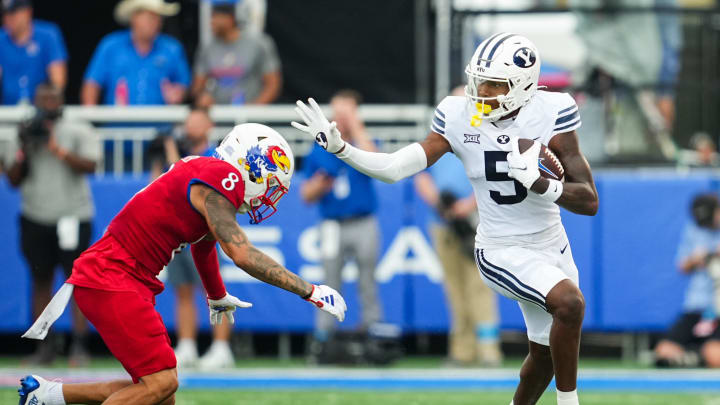 Sep 23, 2023; Lawrence, Kansas, USA; Brigham Young Cougars wide receiver Darius Lassiter (5) runs with the ball against Kansas Jayhawks cornerback Kwinton Lassiter (8) during the first half at David Booth Kansas Memorial Stadium.