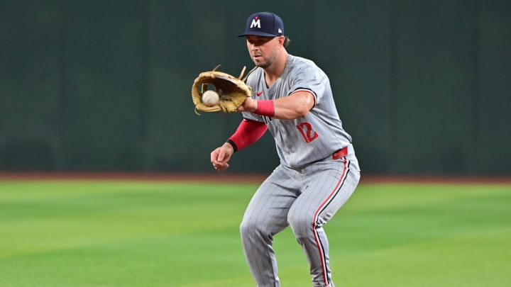 Jun 27, 2024; Phoenix, Arizona, USA;  Minnesota Twins second base Kyle Farmer (12) fields a ground ball in the third inning against the Arizona Diamondbacks at Chase Field. Mandatory Credit: Matt Kartozian-USA TODAY Sports