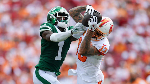 Colts cornerback Sauce Gardner (green jersey) fights for a pass against Tampa Bay receiver Mike Evans.