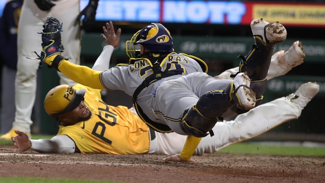 May 23, 2025; Pittsburgh, Pennsylvania, USA;  Milwaukee Brewers catcher William Contreras (24) dives in an attempt to tag Pittsburgh Pirates outfielder Alexander Canario (rear) out at home plate during the tenth inning at PNC Park. Canario was ruled out for leaving the baseline. Mandatory Credit: Charles LeClaire-Imagn Images