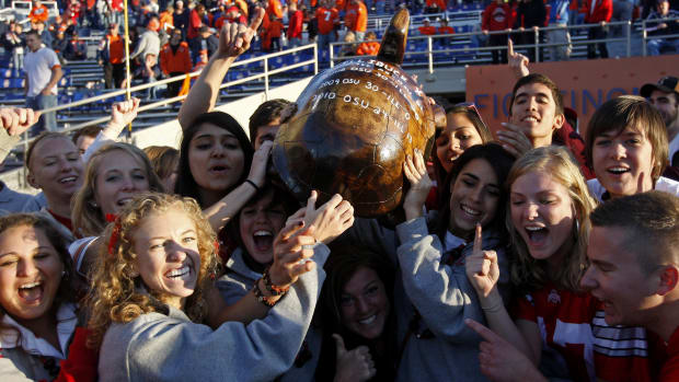 Ohio State Buckeyes fans celebrate with the Illini-Buck trophy during the fourth quarter of the game against Illinois.