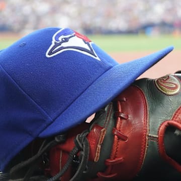 A Toronto Blue Jays hat and glove outside of the dugout during a game against the Texas Rangers at Rogers Centre.