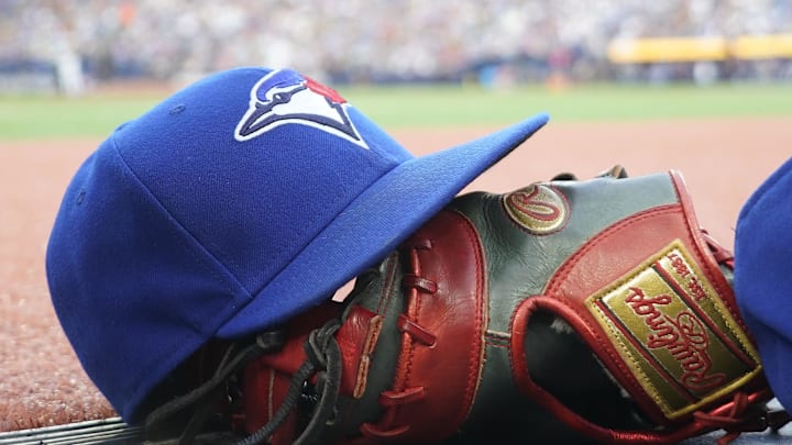 A Toronto Blue Jays hat and glove outside of the dugout during a game against the Texas Rangers at Rogers Centre.