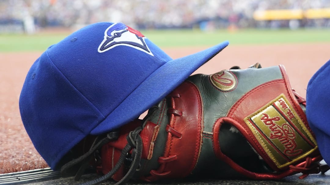 Jul 26, 2024; Toronto, Ontario, CAN; A Toronto Blue Jays hat and glove outside of the dugout during a game against the Texas Rangers at Rogers Centre. Jul 26, 2024; Toronto, Ontario, CAN; A Toronto Blue Jays hat and glove outside of the dugout during a game against the Texas Rangers at Rogers Centre.