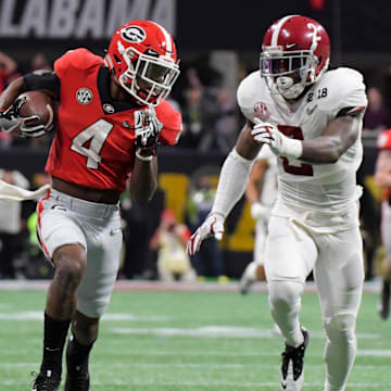 Jan 8, 2018; Atlanta, GA, USA; Georgia Bulldogs wide receiver Mecole Hardman (4) runs the ball for a touchdown ahead of Alabama Crimson Tide defensive back Tony Brown (2) during the third quarter in the 2018 CFP national championship college football game at Mercedes-Benz Stadium. Mandatory Credit: Kirby Lee-Imagn Images