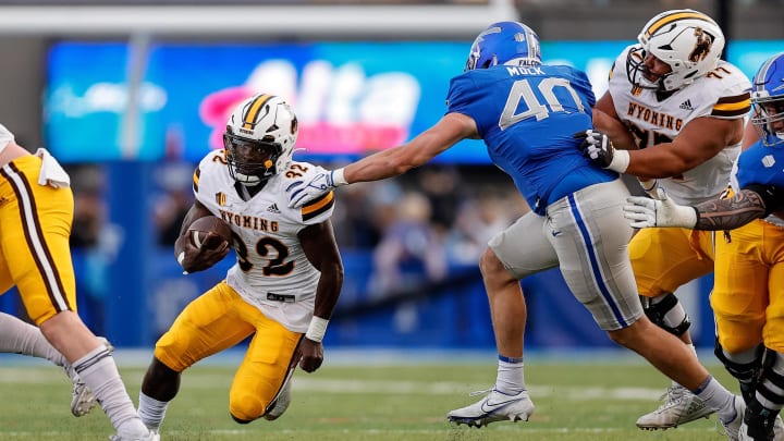 Oct 14, 2023; Colorado Springs, Colorado, USA; Wyoming Cowboys running back Jamari Ferrell (32) runs the ball against Air Force Falcons linebacker Alec Mock (40) as center Nofoafia Tulafono (77) defends in the second quarter at Falcon Stadium. 