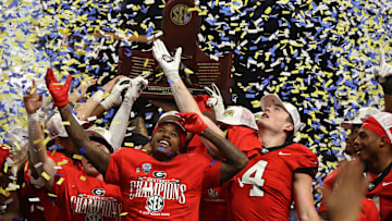 Dec 7, 2024; Atlanta, GA, USA; The Georgia Bulldogs celebrate with the trophy after defeating the Texas Longhorns in overtime in the 2024 SEC Championship game at Mercedes-Benz Stadium. Mandatory Credit: Brett Davis-Imagn Images