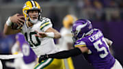 Green Bay Packers quarterback Jordan Love (10) is tackled by Minnesota Vikings linebacker Blake Cashman (51) in the fourth quarter during their football game Sunday, December 29, 2024, at U.S. Bank Stadium in Minneapolis, Minnesota.