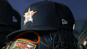 Apr 21, 2023; Atlanta, Georgia, USA; A detailed view of a Houston Astros hat and glove in the dugout against the Atlanta Braves in the fifth inning at Truist Park. Mandatory Credit: Brett Davis-Imagn Images