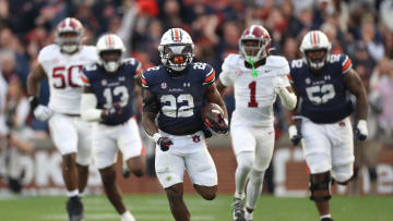 Nov 25, 2023; Auburn, Alabama, USA; Auburn Tigers running back Damari Alston (22) breaks free of Alabama Crimson Tide defenders during the second quarter at Jordan-Hare Stadium. Mandatory Credit: John Reed-USA TODAY Sports