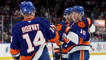Dec 12, 2024; Elmont, New York, USA; New York Islanders right wing Simon Holmstrom (10) celebrates his goal against the Chicago Blackhawks with center Bo Horvat (14) and defenseman Alexander Romanov (28) during the second period at UBS Arena. Mandatory Credit: Brad Penner-Imagn Images