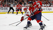 May 15, 2025; Washington, District of Columbia, USA; Washington Capitals defenseman John Carlson (74) skates with the puck on goal as Carolina Hurricanes defenseman Sean Walker (26) defends in the third period in game five of the second round of the 2025 Stanley Cup Playoffs at Capital One Arena. Mandatory Credit: Geoff Burke-Imagn Images