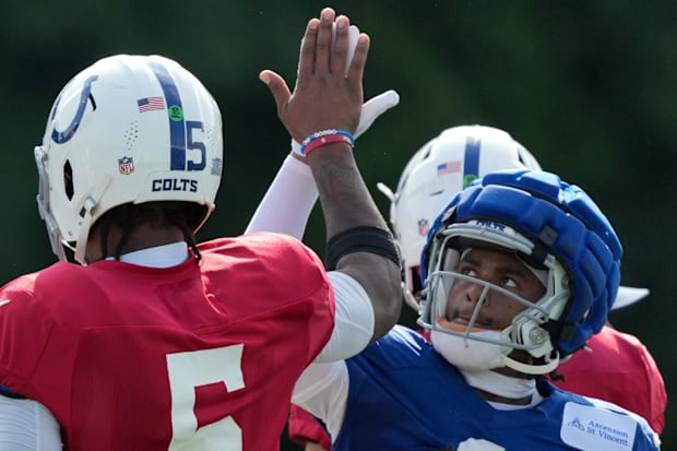 Indianapolis Colts quarterback Anthony Richardson high fives wide receiver Josh Downs in red and blue jerseys.