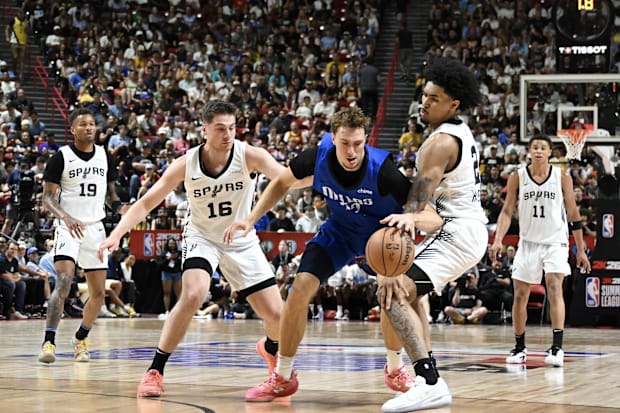 Dallas Mavericks forward Cooper Flagg (32) dribbles against San Antonio Spurs guard Kyle Mangas (16) and guard Dylan Harper (