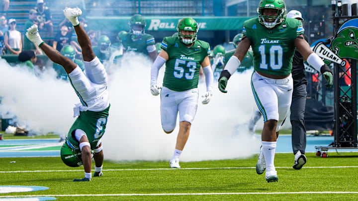 Aug 30, 2025; New Orleans, Louisiana, USA; Tulane Green Wave head coach Jon Sumrall runs out the tunnel with defensive end Gerrod Henderson (10) and safety Tavare Smith (13) against Northwestern Wildcats during the first half at Yulman Stadium. Mandatory Credit: Stephen Lew-Imagn Images