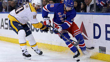 Mar 2, 2025; New York, New York, USA; New York Rangers defenseman Urho Vaakanainen (18) fights for the puck against Nashville Predators center Colton Sissons (10) during the first period at Madison Square Garden. Mandatory Credit: Brad Penner-Imagn Images