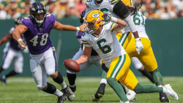 Green Bay Packers quarterback Sean Clifford (6) scrambles away from Baltimore Ravens defensive end Joe Evans (48)