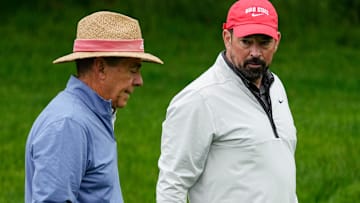 Ohio State football coach Ryan Day talks to former Alabama coach Nick Saban during a golf event in May 2025.