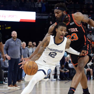 Mar 11, 2022; Memphis, Tennessee, USA; Memphis Grizzlies guard Ja Morant (12) dribbles as New York Knicks center Mitchell Robinson (23) defends during the second half at FedExForum. Mandatory Credit: Petre Thomas-USA TODAY Sports