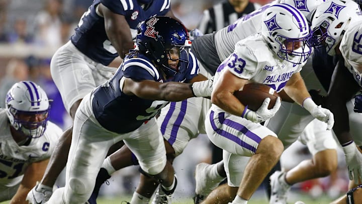 Aug 31, 2024; Oxford, Mississippi, USA; Furman Paladins running back Gavin Hall (33) runs the ball as Mississippi Rebels defensive linemen Chris Hardie (91) attempts to make the tackle during the second half  at Vaught-Hemingway Stadium. Mandatory Credit: Petre Thomas-Imagn Images