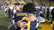 Cal interim head coach Nick Rolovich  hugs quarterback Jaron-Keawe Sagapolutele after defeating SMU. Both have connections to Hawaii