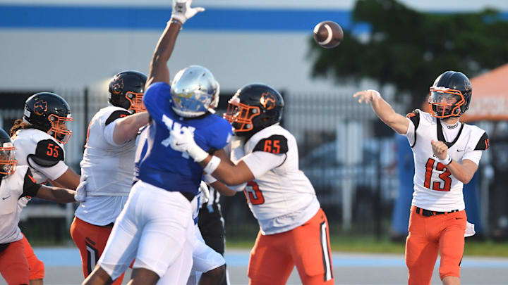 Cocoa High quarterback Brady Hart (#13) throws from his own end zone. The IMG Academy National squad hosted the Cocoa High School Tigers Friday, Sept. 6, 2024 in Bradenton.