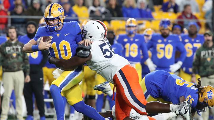 Nov 9, 2024; Pittsburgh, Pennsylvania, USA;  Pittsburgh Panthers quarterback Eli Holstein (10) is tackled by Virginia Cavaliers defensive tackle Anthony Britton (55) during the second quarter at Acrisure Stadium. Mandatory Credit: Charles LeClaire-Imagn Images