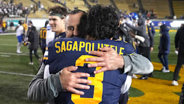 Cal interim head coach Nick Rolovich hugs quarterback Jaron-Keawe Sagapolutele after defeating SMU. 
