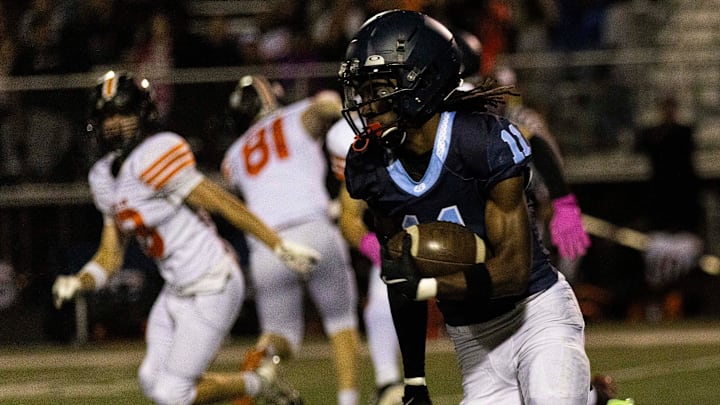 Guilford's Messiah Tilson (11) runs around defense during a game against Harlem on Friday, Sept. 27, 2024, at Guilford High School.