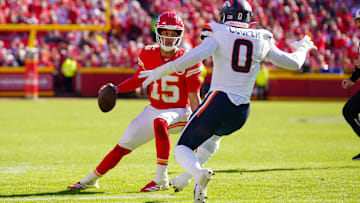 Nov 10, 2024; Kansas City, Missouri, USA; Kansas City Chiefs quarterback Patrick Mahomes (15) scrambles as Denver Broncos linebacker Jonathon Cooper (0) defends during the first half at GEHA Field at Arrowhead Stadium. Mandatory Credit: Denny Medley-Imagn Images