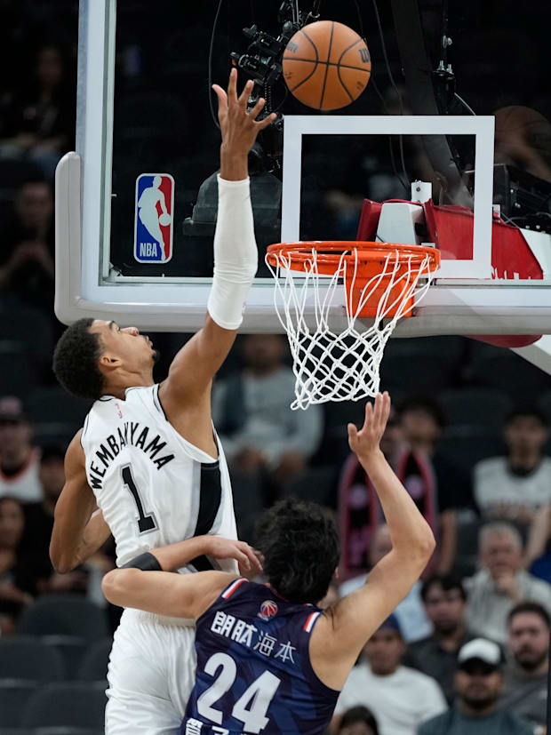 Oct 6, 2025; San Antonio, TX, USA; Victor Wembanyama reaches to block the shot attempt by Guangzhou Loong Lions’ Guan Ziyu. 