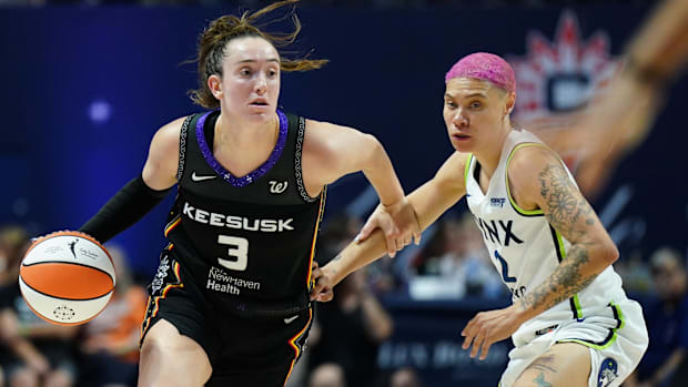 Connecticut Sun guard Marina Mabrey dribbles the ball past a defender while wearing a black uniform