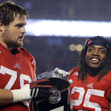 Wisconsin Badgers offensive lineman Rob Havenstein (78), and Wisconsin Badgers running back Melvin Gordon (25) hold the Big Ten West Division trophy Athletic Director Barry Alvarez and coach Gary Anderson watch. Wisconsin beat Minnesota 34-24 to advance to Big Ten Championship