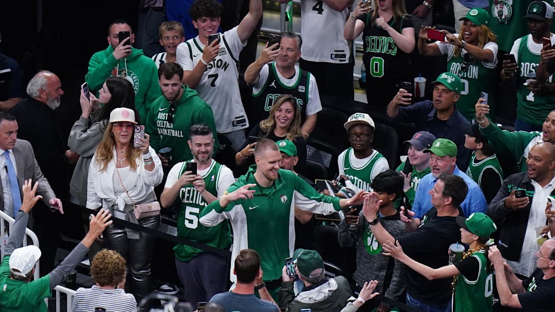 Jun 9, 2024; Boston, Massachusetts, USA; Boston Celtics center Kristaps Porzingis (8) greets fans as he walks onto the court before game two against the Dallas Mavericks in the 2024 NBA Finals at TD Garden. Mandatory Credit: David Butler II-Imagn Images