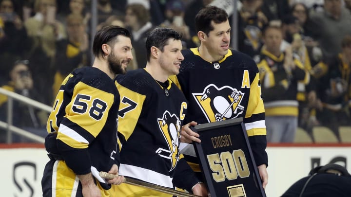 Feb 20, 2022; Pittsburgh, Pennsylvania, USA;  Pittsburgh Penguins defenseman Kris Letang (58) and center Evgeni Malkin (71) present center Sidney Crosby (87) with a commemorative stick and plaque in honor of his 500th  career NHL goal before the game against  the Carolina Hurricanes at PPG Paints Arena. Mandatory Credit: Charles LeClaire-USA TODAY Sports