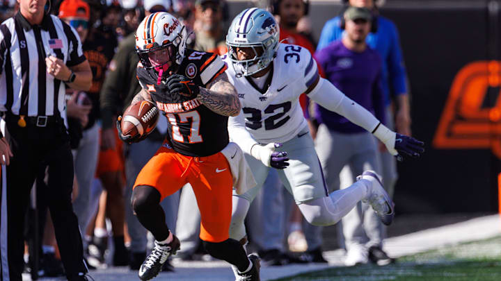 Nov 15, 2025; Stillwater, Oklahoma, USA; Oklahoma State Cowboys wide receiver Gavin Freeman (17) runs the ball around Kansas State Wildcats linebacker Des Purnell (32) during the first half at Boone Pickens Stadium. Mandatory Credit: William Purnell-Imagn Images