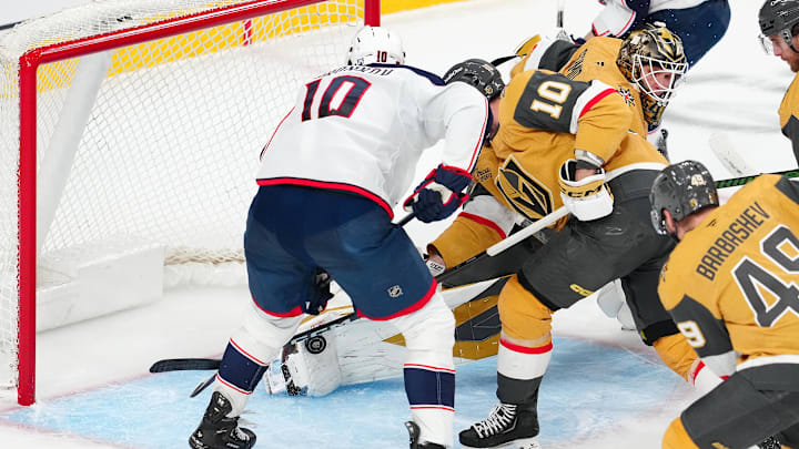Jan 8, 2026; Las Vegas, Nevada, USA; Vegas Golden Knights goaltender Akira Schmid (40) makes a save as center Colton Sissons (10) and Columbus Blue Jackets left wing Dmitri Voronkov (10) look to control the rebound during the third period at T-Mobile Arena. Mandatory Credit: Stephen R. Sylvanie-Imagn Images