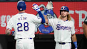 Texas Rangers catcher Jonah Heim (28) slaps the hand of right fielder Travis Jankowski (16) after hitting a two-run home run during the second inning against the Oakland Athletics at Globe Life Field. 