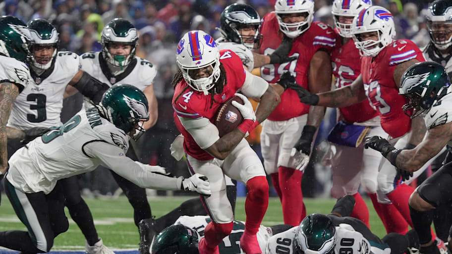 Buffalo Bills running back James Cook III finds a hole and runs through it avoiding several Eagles.