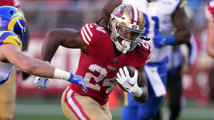 Jan 7, 2024; Santa Clara, California, USA; San Francisco 49ers running back Jordan Mason (24) carries the ball against Los Angeles Rams linebacker Christian Rozeboom (far left) during the second quarter at Levi's Stadium. Mandatory Credit: Darren Yamashita-USA TODAY Sports