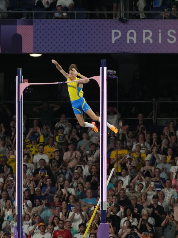 Swedish pole vaulter Armand Duplantis clears the bar to set a new world record at the Paris Olympics. 