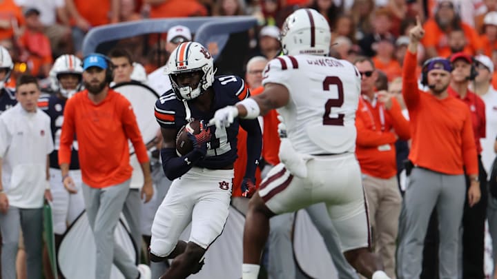 Aug 31, 2024; Auburn, Alabama, USA;  Auburn Tigers wide receiver Malcolm Simmons (11) runs after making a catch against Alabama A&M Bulldogs defensive back Kaleb Dawson (2) during the first quarter at Jordan-Hare Stadium. Mandatory Credit: John Reed-Imagn Images