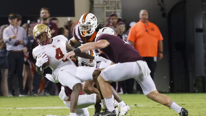 Sep 10, 2022; Blacksburg, Virginia, USA;  Virginia Tech Hokies defensive back Dorian Strong (bottom) and defensive back Jalen Stroman (26) along with Virginia Tech Hokies linebacker Dax Hollifield (right) tackle Boston College Eagles wide receiver Zay Flowers (4) during the second quarter at Lane Stadium. Mandatory Credit: Reinhold Matay-USA TODAY Sports