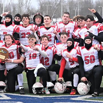 The Morrisville-Eaton Mavericks pose with their championship plaque after beating the Eldred Yellowjackets 40-12 in New York's state regional eight-player football championship game at Cicero-North Syracuse High School's Michael J. Bragman Athletic Complex Sunday, Nov. 30, 2025, in Cicero, New York.
