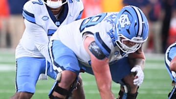 Oct 31, 2025; Syracuse, New York, USA; North Carolina Tar Heels quarterback Gio Lopez (7) with center Austin Blaske (58) at the line of scrimmage in the third quarter against the Syracuse Orange at the JMA Wireless Dome. 