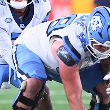 Oct 31, 2025; Syracuse, New York, USA; North Carolina Tar Heels quarterback Gio Lopez (7) with center Austin Blaske (58) at the line of scrimmage in the third quarter against the Syracuse Orange at the JMA Wireless Dome. 