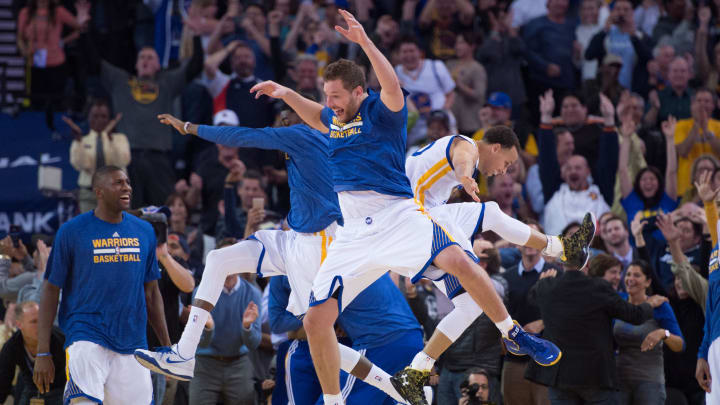 Golden State Warriors guard Justin Holiday (7, left), forward David Lee (10, center), and guard Stephen Curry (30, right) celebrate after Curry made a three-point basket against the Phoenix Suns at Oracle Arena.